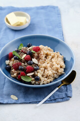 Oatmeal with raspberries, blueberries, honey, almond petals and chia seeds. Healthy breakfast.