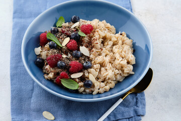 Oatmeal with raspberries, blueberries, honey, almond petals and chia seeds. Healthy breakfast.