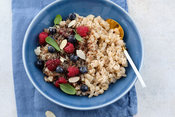 Oatmeal with raspberries, blueberries, honey, almond petals and chia seeds. Healthy breakfast.