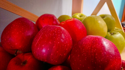A Few Red And Green Apples Stand On A Wooden Shelf