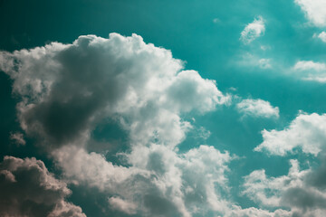 White cotton wool clouds on a sunny day. A continuous stream of clouds across the summer sky.