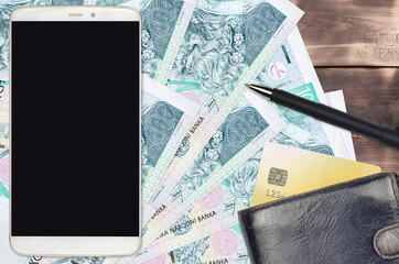 100 Czech korun bills and smartphone with purse and credit card. E-payments or e-commerce concept....