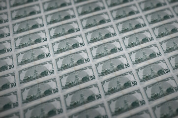 50 US dollars bills printed in illegal money production conveyor. Collage of many fake bills....
