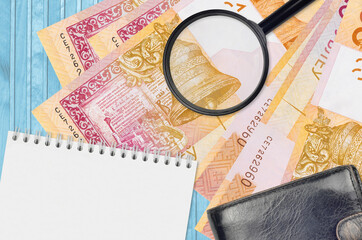 20 Belorussian rubles bills and magnifying glass with black purse and notepad. Concept of...