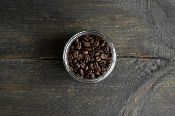 Obraz na płótnie Canvas Fresh arabica coffee beans in a little jar on a wooden table. Fresh coffee beans.