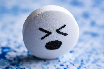 Big white cute Pill with drawn face smile on color background. the concept of antidepressants