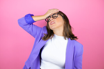 Young beautiful business woman over isolated pink background putting one hand on her head smiling...