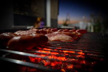 View of a half-done barbecue with sausages, hamburgers, pork and bacon. Selective focus