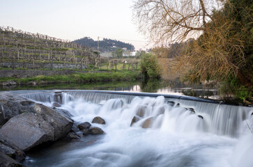 cascade of water in a river in Portugal with autumn landscape - long exposure
