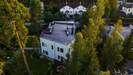Fototapeta na wymiar Top drone view of private house in cottage village. Modern exterior. Green trees.