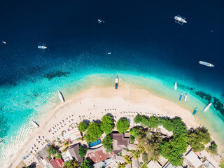 Gili island with white tropical beach and turquoise crystal ocean, aerial view.