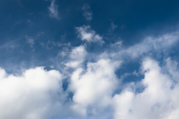 White cotton wool clouds on a sunny day. A continuous stream of clouds across the summer sky.