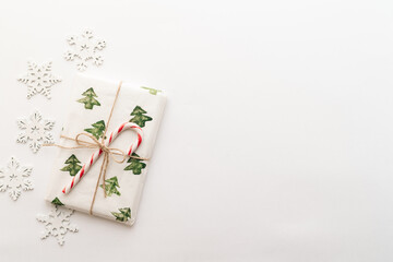 Christmas composition. Gifts, red and green Christmas candies, snowflakes on a white background. The concept of Christmas, winter, New year. Flat layout, top view, copy space.