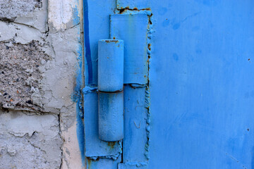 Hinged iron hinges on garage doors in blue