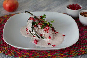 Chile poblano en nogada relleno de carne en plato blanco