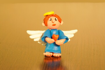 Figure of a guardian angel with a heart on a uniform background.