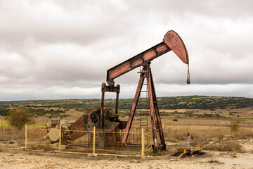 Oil pump with cloudy sky in the Las Loras oil field in Burgos. Located in the north of Spain. Castilla and Leon