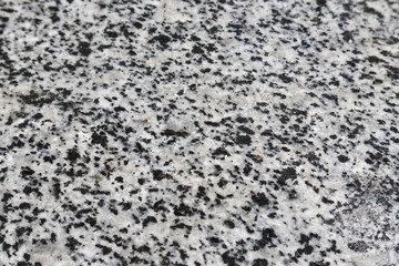 Perspective view of unpolished surface of granite slab with black and grey texture.