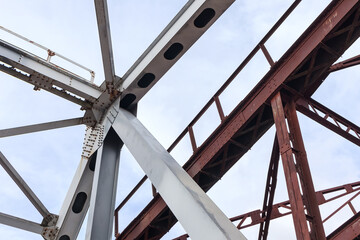 Fototapeta premium Some part of new and old steel construction of train bridge, construction details with metal girders, bolts and nuts.