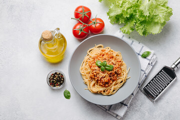 Traditional italian pasta spaghetti with bolognese meat sauce and parmesan on a light concrete, stone background