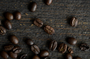 Roasted arabica coffee beans scattered on a wooden table. Fresh coffee beans.