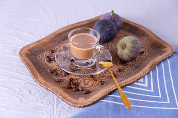 a cup of aromatic coffee with milk stands on a wooden tray