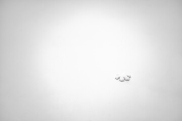 One small white snowflake on a white background. The concept of winter, the first snow