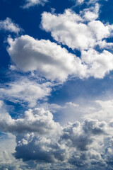 Beautiful white clouds in a semicircle against the blue sky. Vertical photo