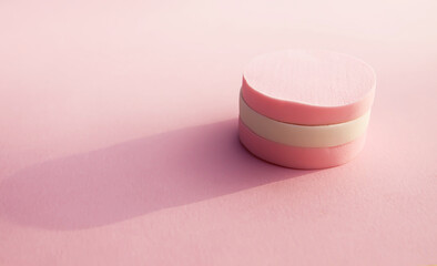 Cosmetic sponges in pastel colors on a pink background