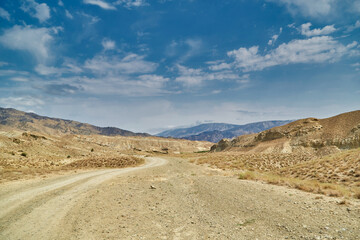 Fototapeta na wymiar a sandy road in the mountains of Asia. sand surface dried without rain