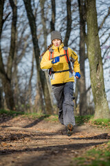 Naklejka premium Young traveler woman with backpack travel in forest, rocky places with a tent