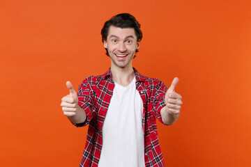 Excited cheerful funny young brunet man 20s wearing white t-shirt red checkered shirt posing...