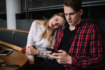 Young man and woman with smartphone in cafe