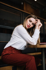 Stylish woman sitting on sofa in modern place