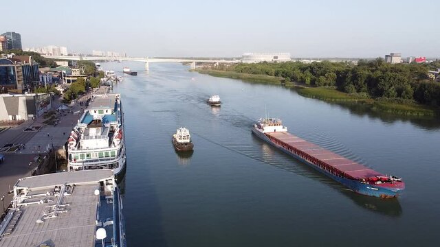 barge and boats float on the river and panorama of city at sunset aerial view