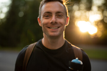 Young man smiling at the camera in park