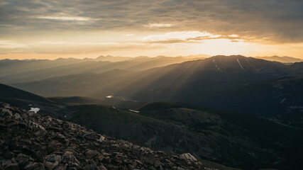 Sunrise over Mountain Peak. Gold sunlight coming through.