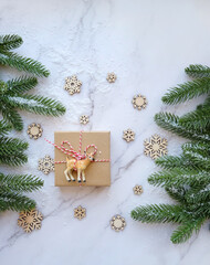 Fototapeta na wymiar Christmas and New Year holiday concept. Gift box, deer toy, snowflakes and fir tree. copy space. flat lay