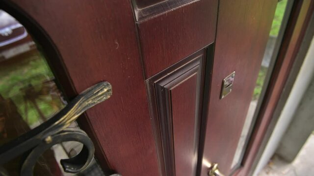 Top view of a fragment of the front door, a hand knocks on the door, then an employee glues a notice of eviction of the tenant