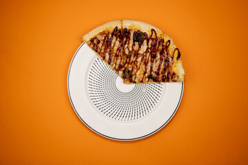 Three slices of pizza on a plate and orange background