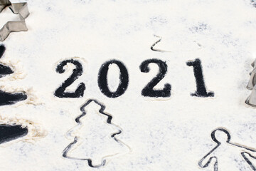 Numbers 2021 in flour on a black background. The symbol of the new year. Celebrating New Year 2021.