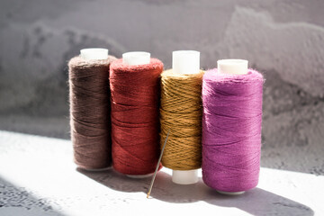 Multicolored spools of thread on light background. Side view