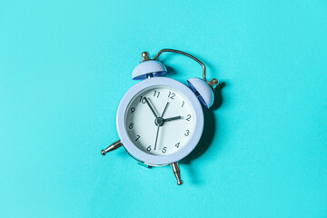 Simply minimal design ringing twin bell vintage classic alarm clock Isolated on blue pastel background. Rest hours time of life good morning night wake up awake concept. Flat lay top view, copy space