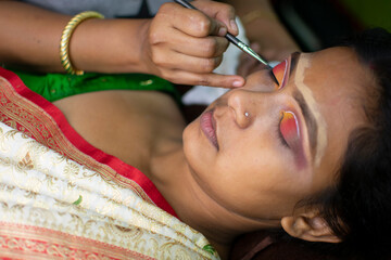 an indian woman getting bridal makeup