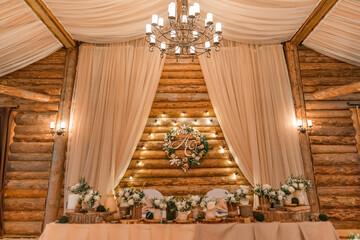 Wedding decor  in rustic style. The newlyweds' table decorated with bouquets of white roses,...