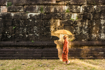 Monk with umbrella , Bakong Temple ruins (part of the Roluos Group of pre-Angkorian Hindu temples), Bakong, Cambodia