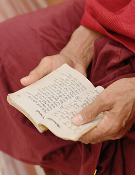 Close up of buddhist monk holding scripture book, Burma
