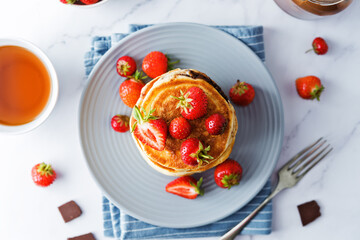 Pancakes with chocolate nutella filling decorated with strawberries