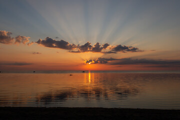 Sun in clouds during sunrise over sea