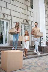 Young family carrying cardboards while getting ready to move